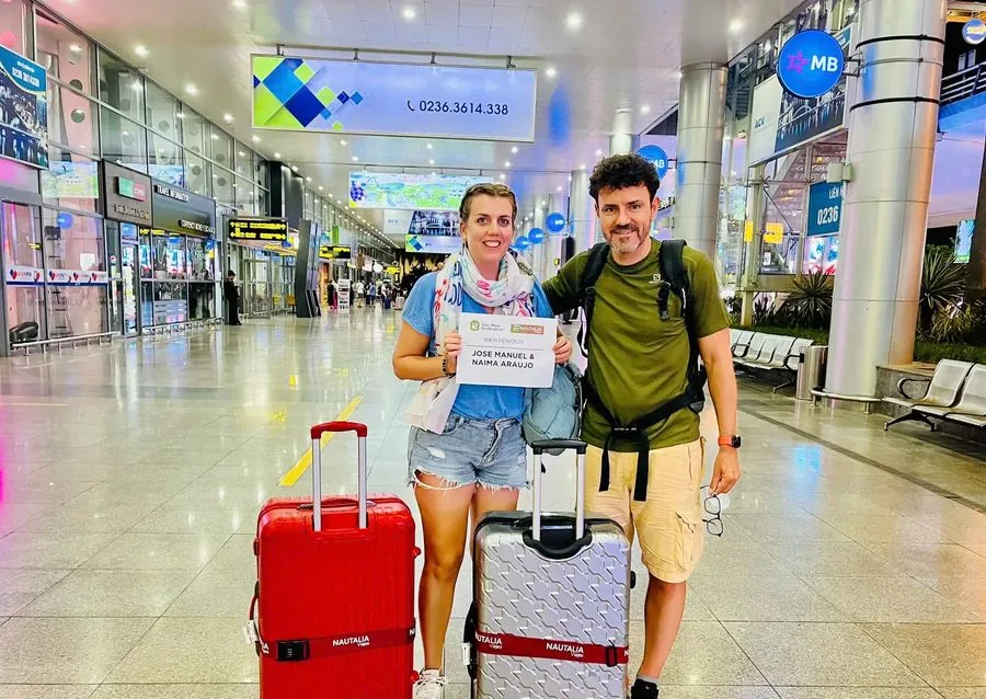 Couple arriving at Da Nang Airport with welcome sign