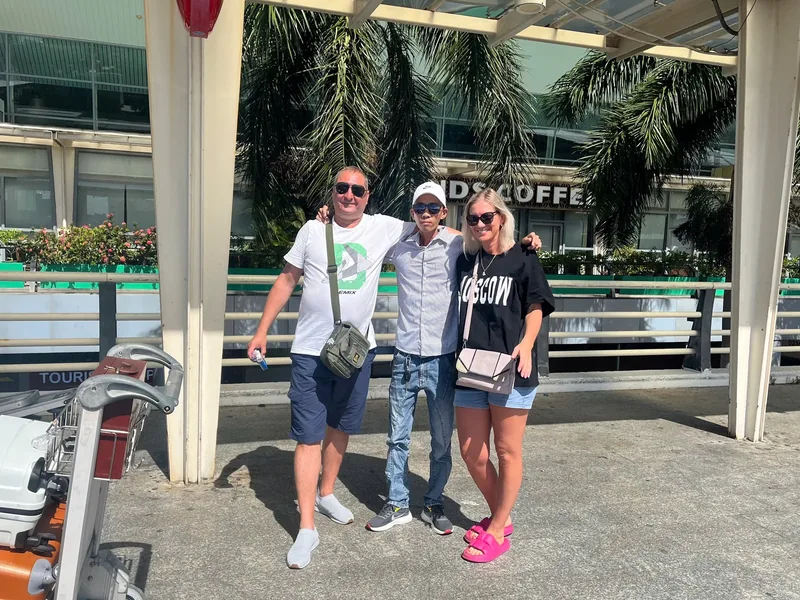 Minh Vu Travel driver with guests outside Da Nang Airport — transfer complete, ready for Hoi An — Central Vietnam