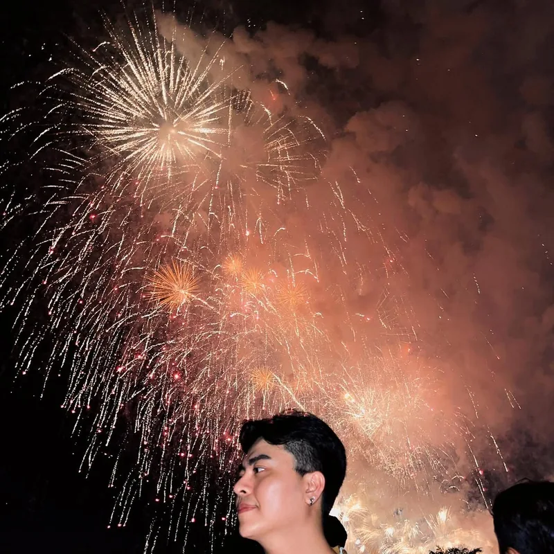 Visitor at DIFF Da Nang fireworks festival watching golden fireworks light up the sky — unforgettable evening on the Han River