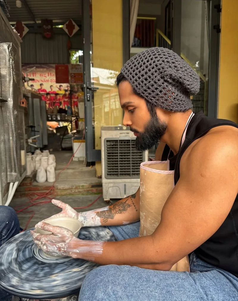 Traveler fully focused on pottery wheel at Thanh Ha Village near Hoi An Ancient Town — hands-on craft experience