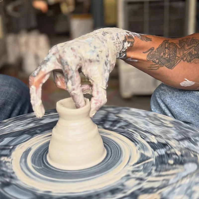 Close-up of hands shaping clay on a spinning pottery wheel at Thanh Ha Village Hoi An — workshop experience for visitors