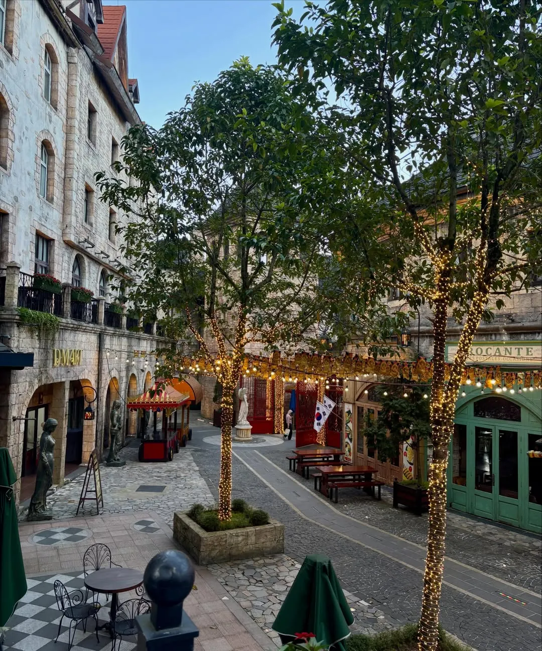 Ba Na Hills French Village dining street at dusk with fairy lights — restaurants and cafés in the European cobblestone precinct