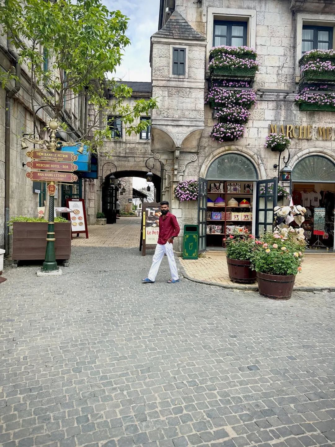 Restaurant and dining signpost in Ba Na Hills French Village pointing to Le Petrin Cake Shop and L'etable Restaurant among the à la carte options