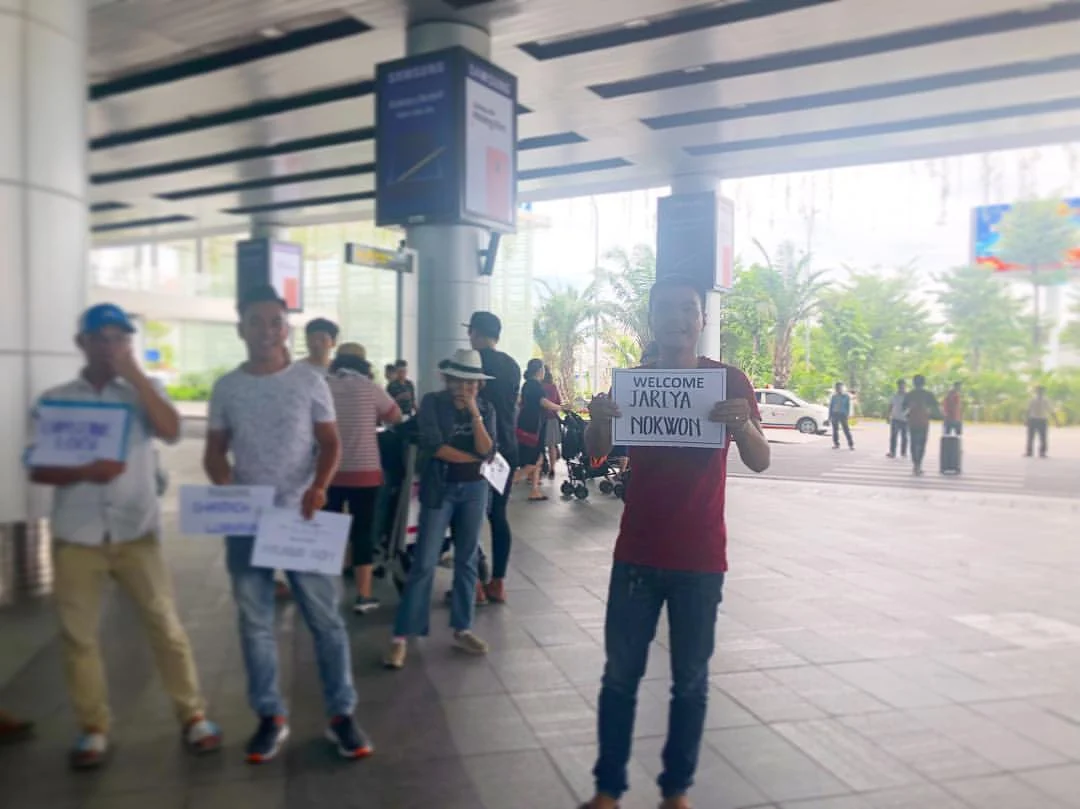 Drivers waiting with name signs at Da Nang Airport arrival pickup area