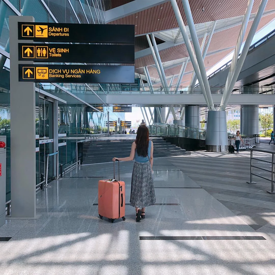 Passenger with suitcase inside Da Nang Airport Terminal 2 departure hall
