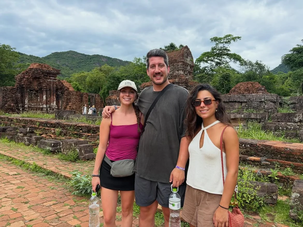Travellers visiting ancient Cham temple ruins in the green valley of My Son Sanctuary near Hoi An and Da Nang