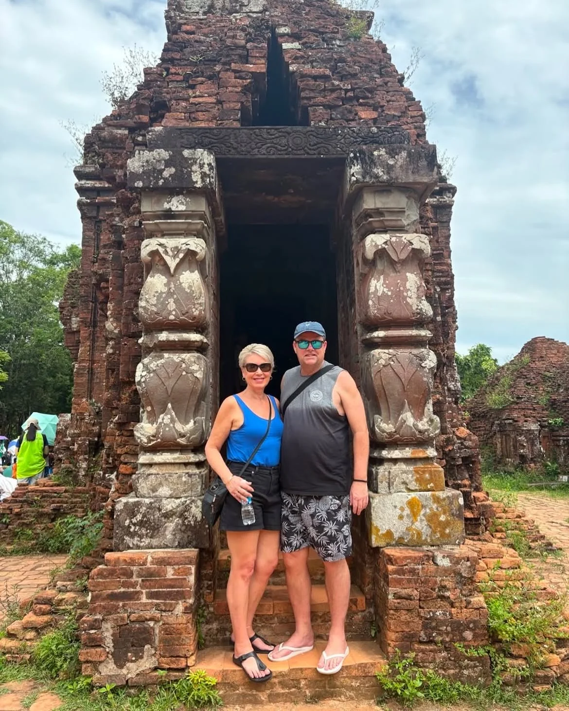 Couple standing at an ancient Cham tower doorway inside My Son Sanctuary