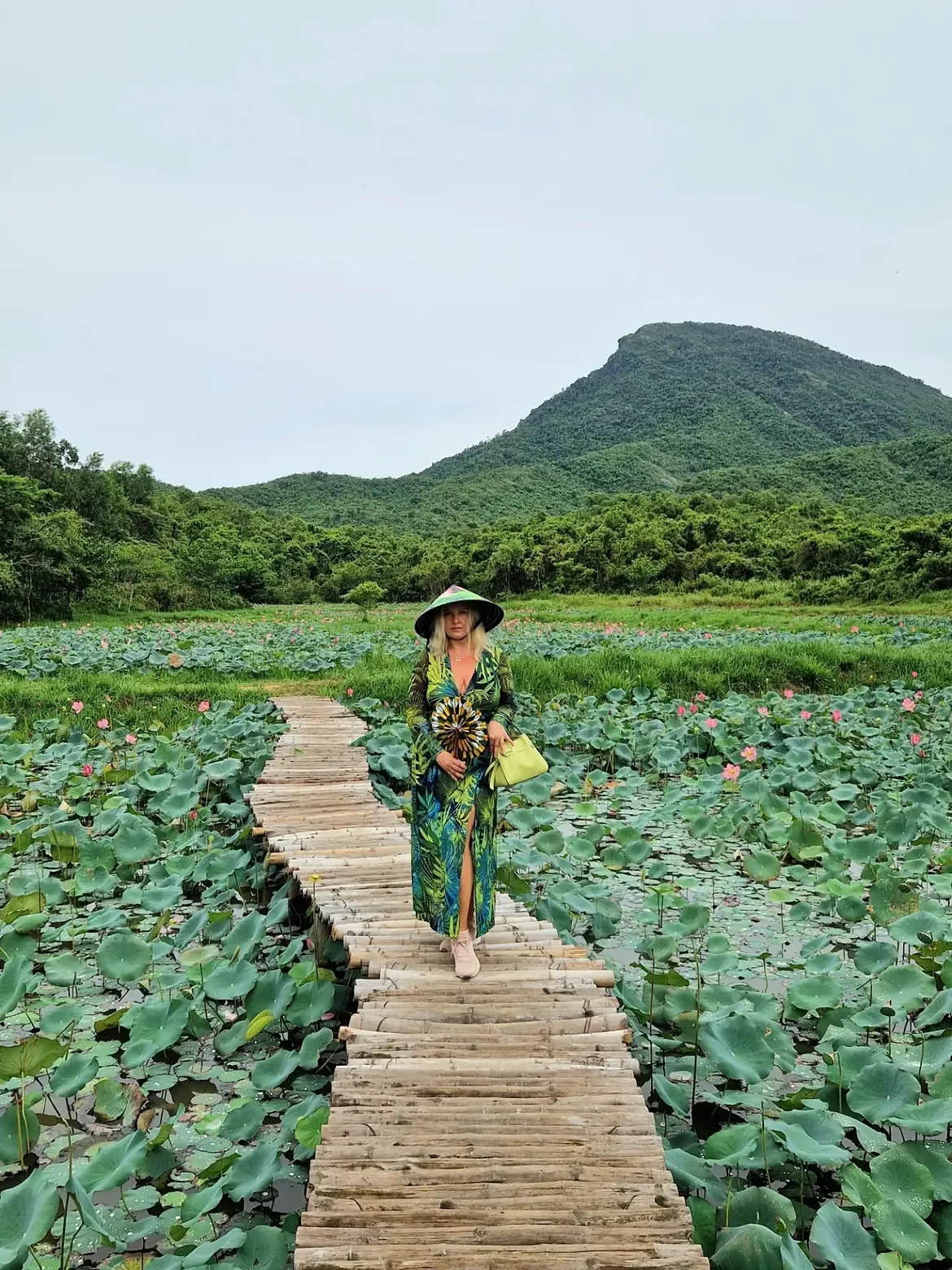 Traveller checking in at the lotus pond with mountains behind My Son Sanctuary