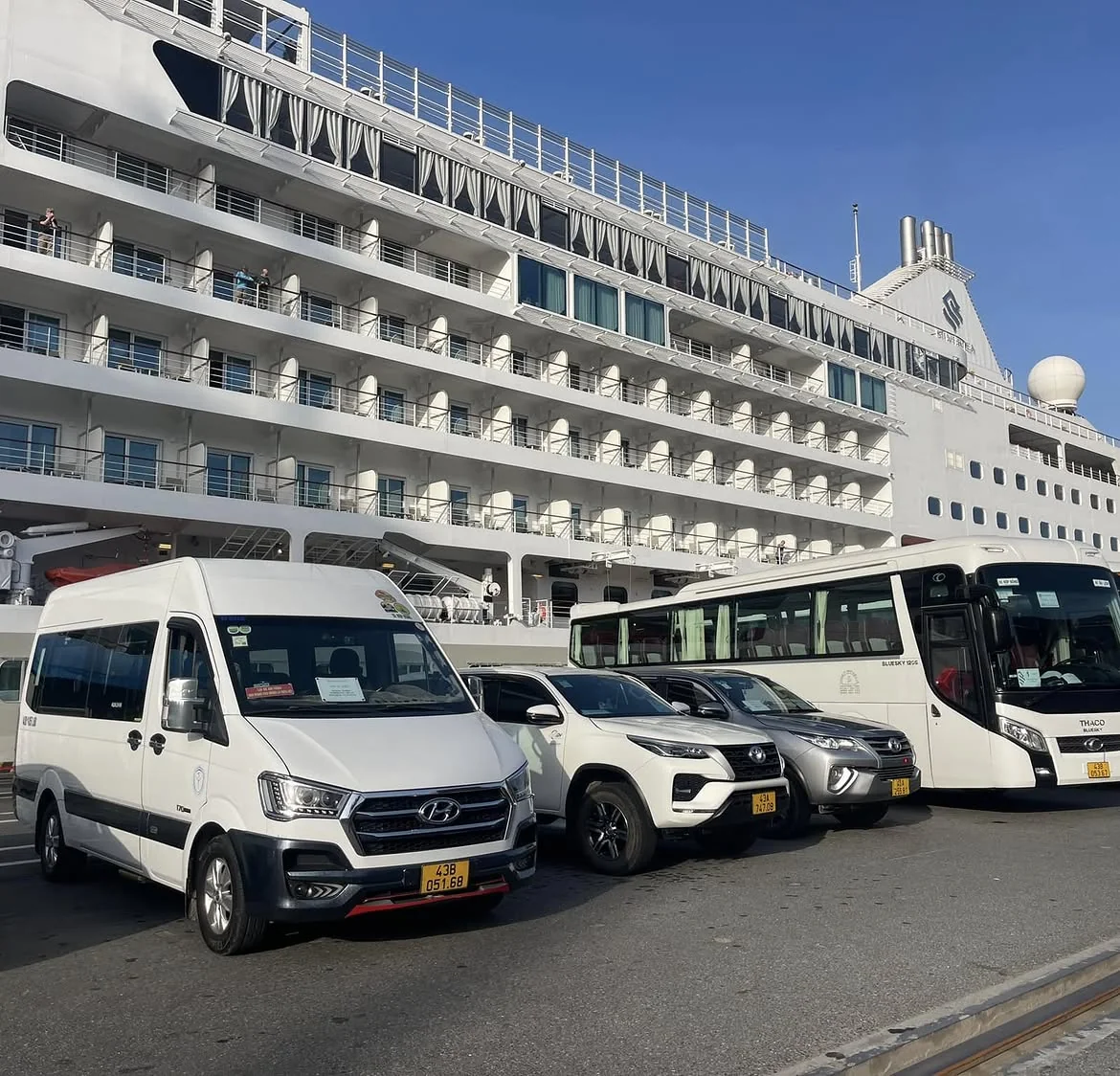 Private cars and vans waiting beside a cruise ship at Chan May Port for shore excursion passengers