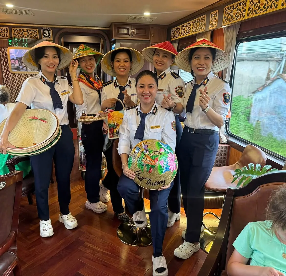 Onboard staff on the Da Nang to Hue heritage train showing the tourist-style train experience before arriving in Hue