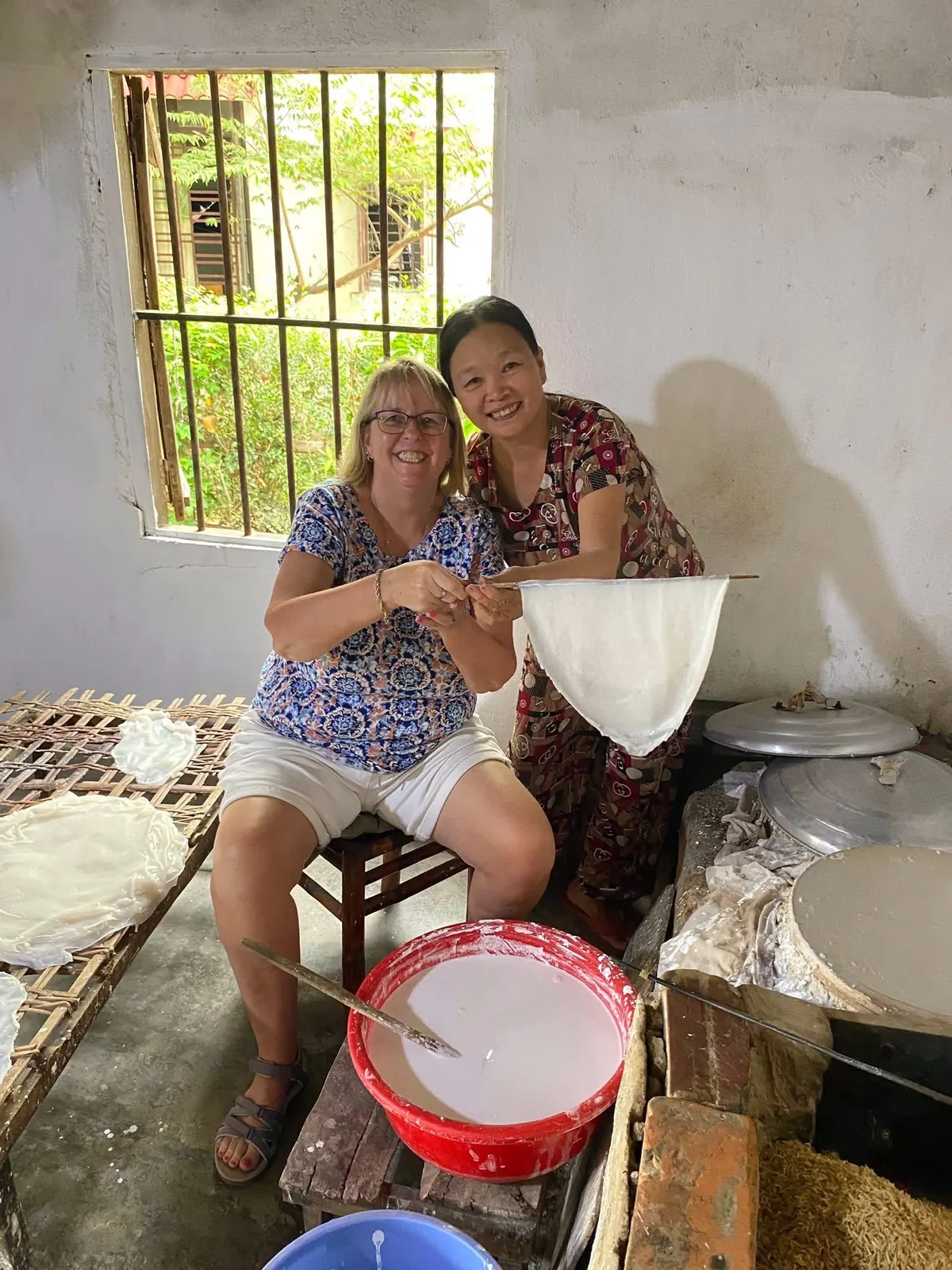 Guest learning traditional rice paper making with a local family in Cam Kim Hoi An